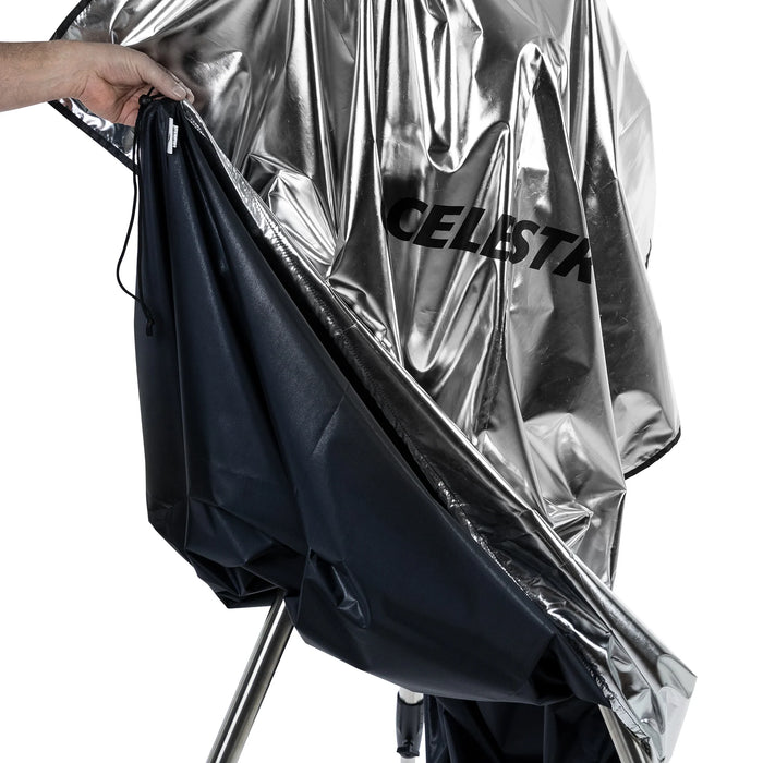 Celestron Weatherproof Telescope Cover draped over a mounted telescope outdoors, showing full-length protection from optical tube to tripod legs.