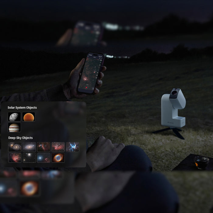 Person using a smartphone app to identify celestial objects with a telescope in the background.